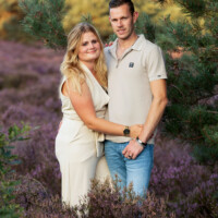 Lisa met haar vriend tijdens een loveshoot in de bloeiende heide bij de Zwarte Dennen